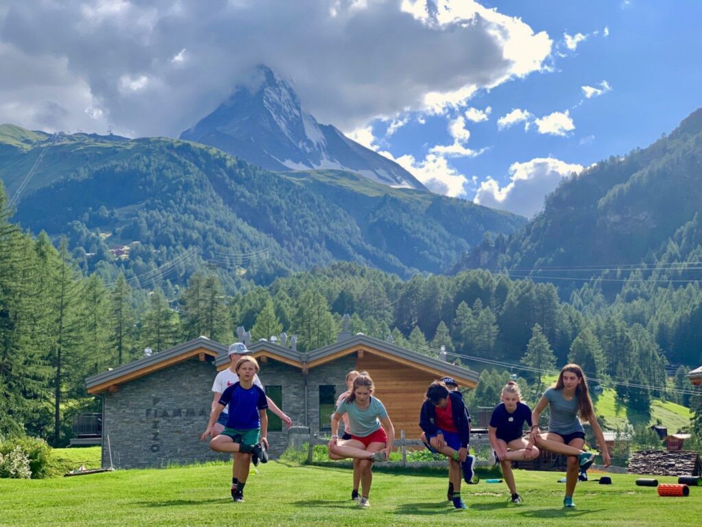 Mt. Mansfield Academy athletes at an off-season camp practicing a balancing pose.